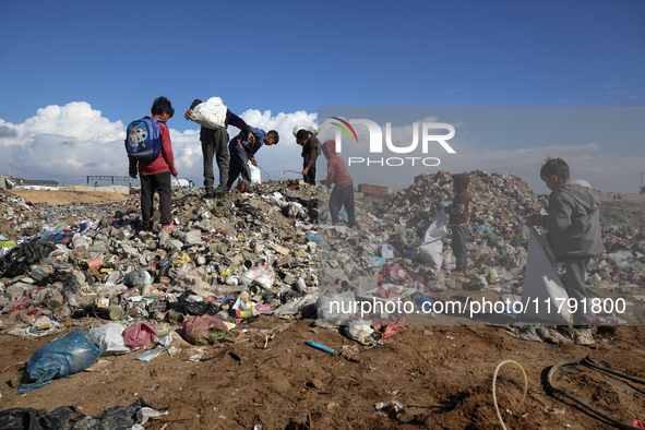 A Palestinian searches through a pile of garbage in Khan Yunis, Gaza Strip, on November 19, 2024, amid the ongoing war between Israel and th...