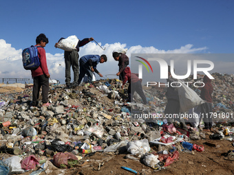 A Palestinian searches through a pile of garbage in Khan Yunis, Gaza Strip, on November 19, 2024, amid the ongoing war between Israel and th...