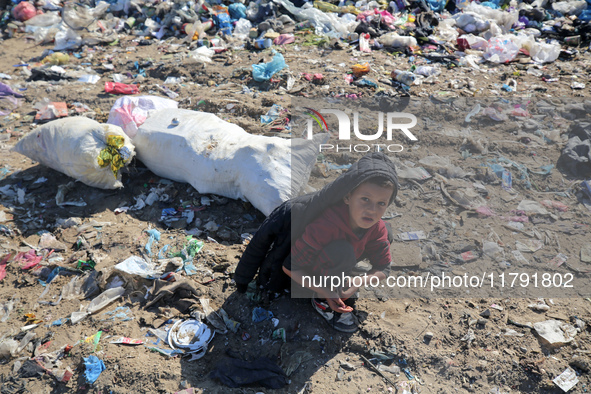 A displaced Palestinian boy searches through a pile of garbage in Khan Yunis, Gaza Strip, on November 19, 2024, amid the ongoing war between...