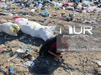 A displaced Palestinian boy searches through a pile of garbage in Khan Yunis, Gaza Strip, on November 19, 2024, amid the ongoing war between...