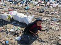 A displaced Palestinian boy searches through a pile of garbage in Khan Yunis, Gaza Strip, on November 19, 2024, amid the ongoing war between...