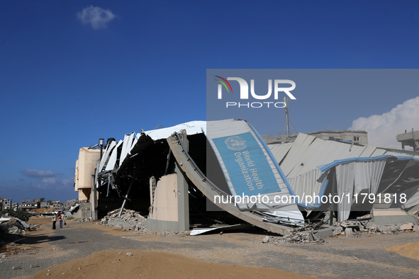 A displaced Palestinian girl walks past a damaged World Health Organisation storage center hit in recent Israeli bombardment in Khan Yunis,...