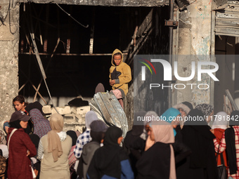 Displaced and local Palestinian residents of Khan Yunis wait outside a bakery for fresh bread in the southern Gaza Strip city on November 19...