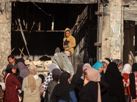 Displaced and local Palestinian residents of Khan Yunis wait outside a bakery for fresh bread in the southern Gaza Strip city on November 19...