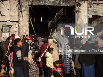 Displaced and local Palestinian residents of Khan Yunis wait outside a bakery for fresh bread in the southern Gaza Strip city on November 19...