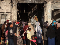 Displaced and local Palestinian residents of Khan Yunis wait outside a bakery for fresh bread in the southern Gaza Strip city on November 19...