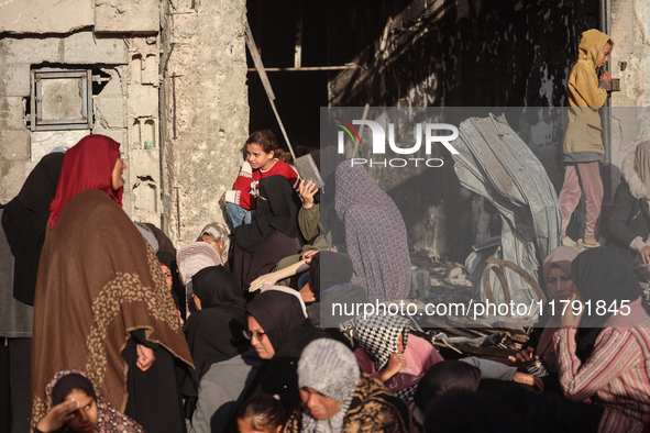 Displaced and local Palestinian residents of Khan Yunis wait outside a bakery for fresh bread in the southern Gaza Strip city on November 19...