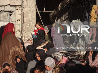 Displaced and local Palestinian residents of Khan Yunis wait outside a bakery for fresh bread in the southern Gaza Strip city on November 19...