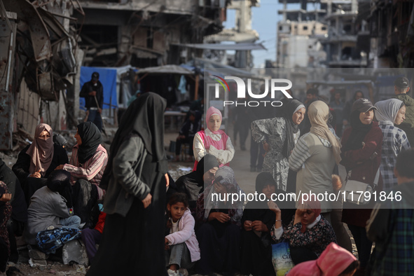 Displaced and local Palestinian residents of Khan Yunis wait outside a bakery for fresh bread in the southern Gaza Strip city on November 19...