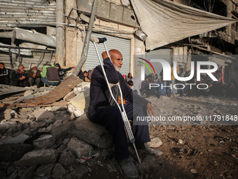 Displaced and local Palestinian residents of Khan Yunis wait outside a bakery for fresh bread in the southern Gaza Strip city on November 19...