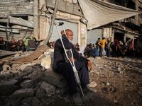 Displaced and local Palestinian residents of Khan Yunis wait outside a bakery for fresh bread in the southern Gaza Strip city on November 19...