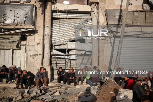 Displaced and local Palestinian residents of Khan Yunis wait outside a bakery for fresh bread in the southern Gaza Strip city on November 19...