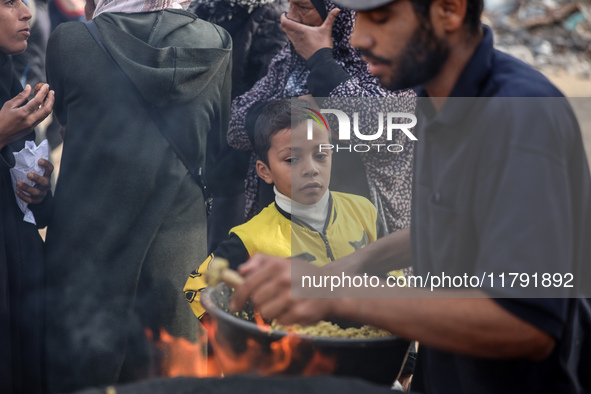 Palestinians wait for their falafel orders at a makeshift takeaway spot in Khan Yunis, Gaza Strip, on November 19, 2024, amid the ongoing wa...