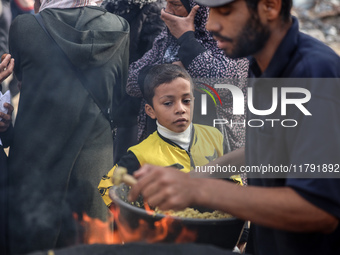 Palestinians wait for their falafel orders at a makeshift takeaway spot in Khan Yunis, Gaza Strip, on November 19, 2024, amid the ongoing wa...