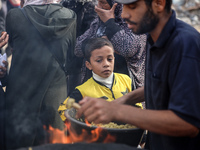 Palestinians wait for their falafel orders at a makeshift takeaway spot in Khan Yunis, Gaza Strip, on November 19, 2024, amid the ongoing wa...