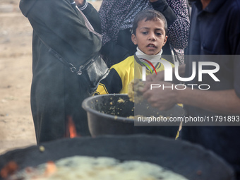 Palestinians wait for their falafel orders at a makeshift takeaway spot in Khan Yunis, Gaza Strip, on November 19, 2024, amid the ongoing wa...