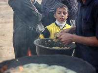 Palestinians wait for their falafel orders at a makeshift takeaway spot in Khan Yunis, Gaza Strip, on November 19, 2024, amid the ongoing wa...