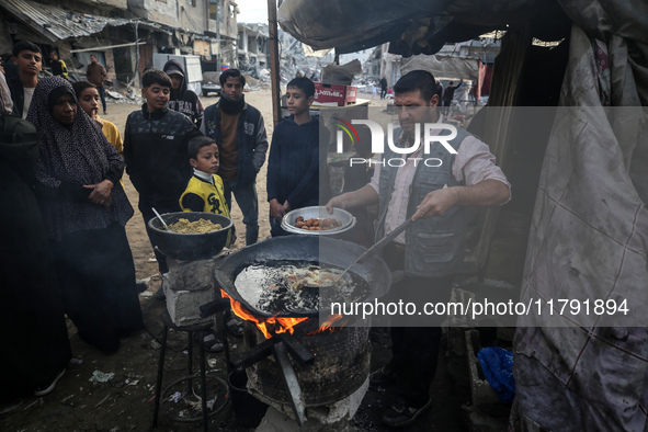 Palestinians wait for their falafel orders at a makeshift takeaway spot in Khan Yunis, Gaza Strip, on November 19, 2024, amid the ongoing wa...