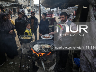 Palestinians wait for their falafel orders at a makeshift takeaway spot in Khan Yunis, Gaza Strip, on November 19, 2024, amid the ongoing wa...