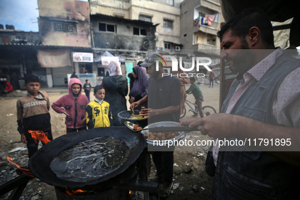 Palestinians wait for their falafel orders at a makeshift takeaway spot in Khan Yunis, Gaza Strip, on November 19, 2024, amid the ongoing wa...