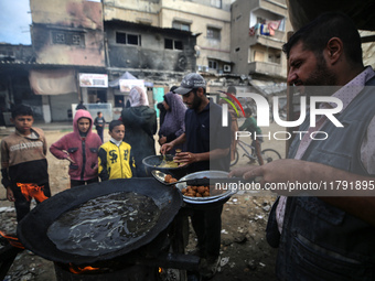 Palestinians wait for their falafel orders at a makeshift takeaway spot in Khan Yunis, Gaza Strip, on November 19, 2024, amid the ongoing wa...