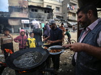 Palestinians wait for their falafel orders at a makeshift takeaway spot in Khan Yunis, Gaza Strip, on November 19, 2024, amid the ongoing wa...