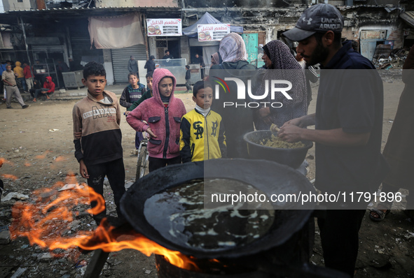 Palestinians wait for their falafel orders at a makeshift takeaway spot in Khan Yunis, Gaza Strip, on November 19, 2024, amid the ongoing wa...