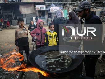 Palestinians wait for their falafel orders at a makeshift takeaway spot in Khan Yunis, Gaza Strip, on November 19, 2024, amid the ongoing wa...