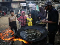 Palestinians wait for their falafel orders at a makeshift takeaway spot in Khan Yunis, Gaza Strip, on November 19, 2024, amid the ongoing wa...