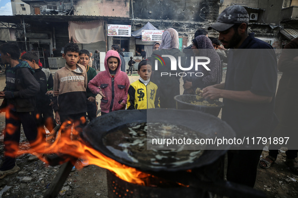 Palestinians wait for their falafel orders at a makeshift takeaway spot in Khan Yunis, Gaza Strip, on November 19, 2024, amid the ongoing wa...