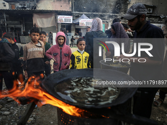 Palestinians wait for their falafel orders at a makeshift takeaway spot in Khan Yunis, Gaza Strip, on November 19, 2024, amid the ongoing wa...