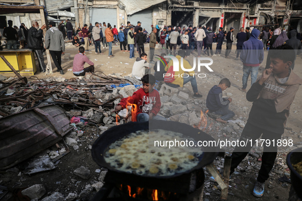 Palestinians wait for their falafel orders at a makeshift takeaway spot in Khan Yunis, Gaza Strip, on November 19, 2024, amid the ongoing wa...