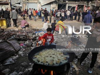 Palestinians wait for their falafel orders at a makeshift takeaway spot in Khan Yunis, Gaza Strip, on November 19, 2024, amid the ongoing wa...