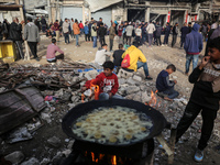 Palestinians wait for their falafel orders at a makeshift takeaway spot in Khan Yunis, Gaza Strip, on November 19, 2024, amid the ongoing wa...