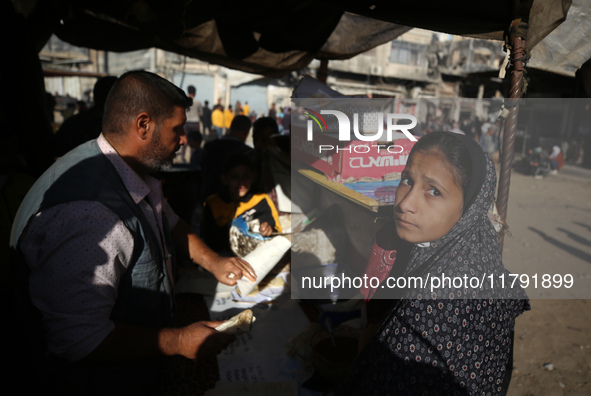 Palestinians wait for their falafel orders at a makeshift takeaway spot in Khan Yunis, Gaza Strip, on November 19, 2024, amid the ongoing wa...