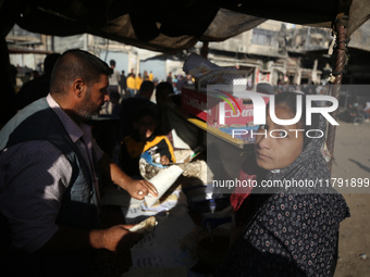 Palestinians wait for their falafel orders at a makeshift takeaway spot in Khan Yunis, Gaza Strip, on November 19, 2024, amid the ongoing wa...