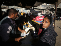 Palestinians wait for their falafel orders at a makeshift takeaway spot in Khan Yunis, Gaza Strip, on November 19, 2024, amid the ongoing wa...