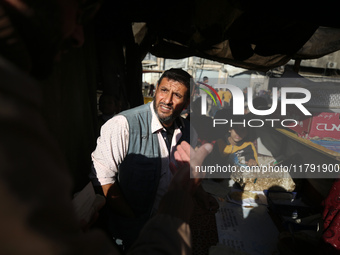 Palestinians wait for their falafel orders at a makeshift takeaway spot in Khan Yunis, Gaza Strip, on November 19, 2024, amid the ongoing wa...