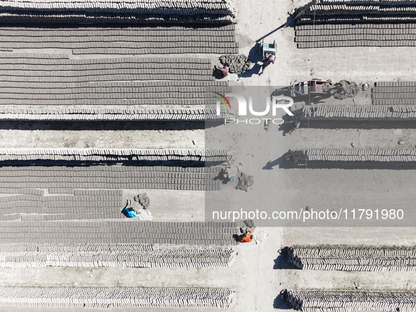 In Feni, Chittagong, Bangladesh, on November 19, 2024, workers mold hundreds of new bricks at a brick kiln. The daily laborers work from 8 a...