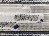 In Feni, Chittagong, Bangladesh, on November 19, 2024, workers mold hundreds of new bricks at a brick kiln. The daily laborers work from 8 a...