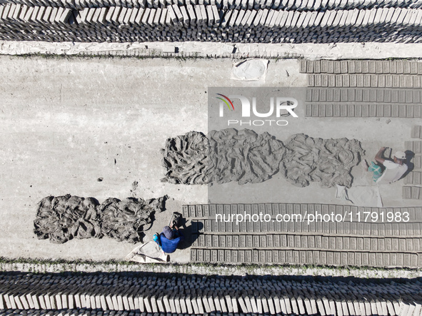 In Feni, Chittagong, Bangladesh, on November 19, 2024, workers mold hundreds of new bricks at a brick kiln. The daily laborers work from 8 a...