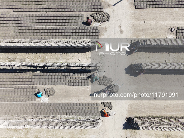 In Feni, Chittagong, Bangladesh, on November 19, 2024, workers mold hundreds of new bricks at a brick kiln. The daily laborers work from 8 a...