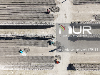 In Feni, Chittagong, Bangladesh, on November 19, 2024, workers mold hundreds of new bricks at a brick kiln. The daily laborers work from 8 a...