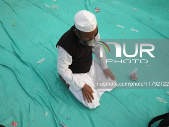 An activist of The All India Youth Federation (AIYF) offers a prayer after attending a protest meeting in Kolkata, India, on November 19, 20...