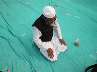 An activist of The All India Youth Federation (AIYF) offers a prayer after attending a protest meeting in Kolkata, India, on November 19, 20...