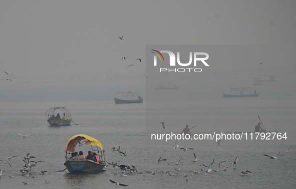 People take boat rides amid heavy smoggy conditions at Sangam, the confluence of the rivers Ganges, Yamuna, and Saraswati, in Prayagraj, Ind...