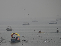 People take boat rides amid heavy smoggy conditions at Sangam, the confluence of the rivers Ganges, Yamuna, and Saraswati, in Prayagraj, Ind...