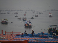 People take boat rides amid heavy smoggy conditions at Sangam, the confluence of the rivers Ganges, Yamuna, and Saraswati, in Prayagraj, Ind...