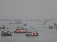 People take boat rides amid heavy smoggy conditions at Sangam, the confluence of the rivers Ganges, Yamuna, and Saraswati, in Prayagraj, Ind...