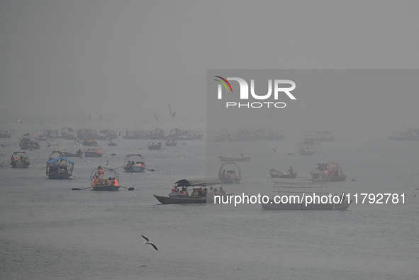 People take boat rides amid heavy smoggy conditions at Sangam, the confluence of the rivers Ganges, Yamuna, and Saraswati, in Prayagraj, Ind...